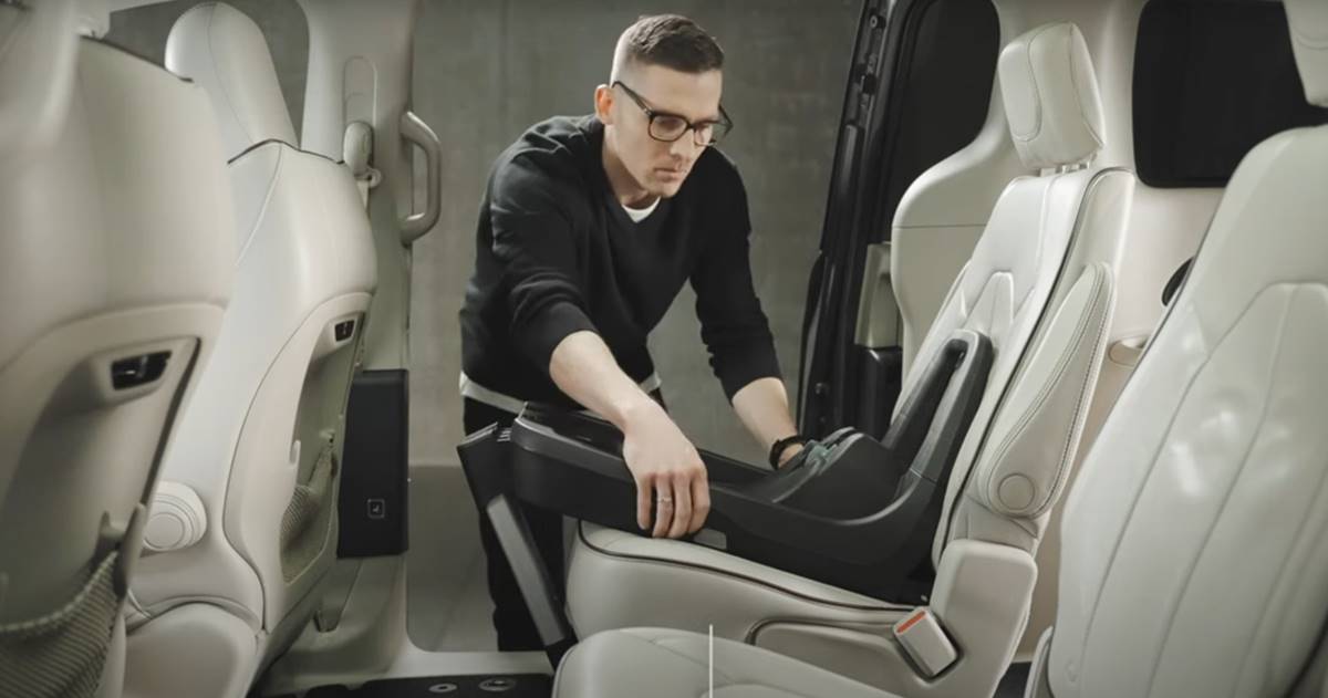Mężczyzna pokazuje jak prawidłowo zamontować bazę isofix w samochodzie
